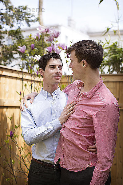 Zärtliches schwules Paar im Hinterhof stehend