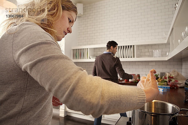 Frau kocht Essen mit Mann in der Küche