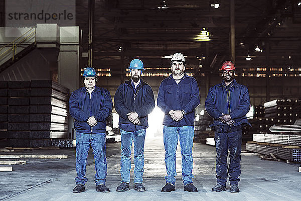 Porträt von Arbeiterinnen und Arbeitern in einem Fabriklager