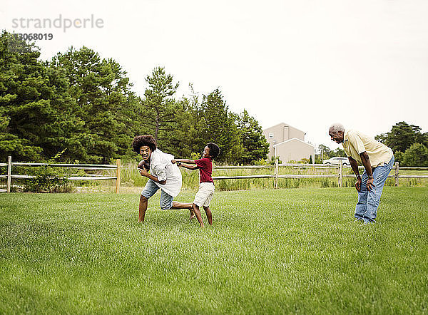 Familie spielt Fussball im Hinterhof