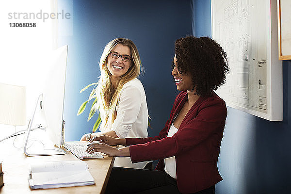 Lächelnde Geschäftsfrauen  die im Büro arbeiten