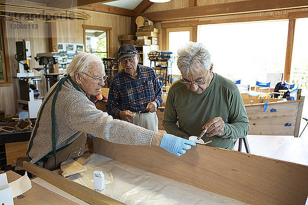 Ältere Arbeiter bei der Kanuherstellung in der Werkstatt