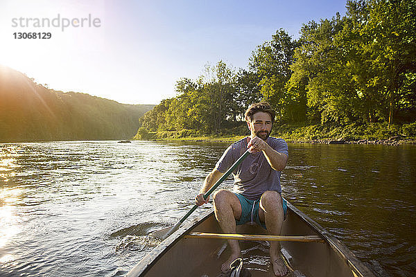 Mann rudert im Kanu sitzend