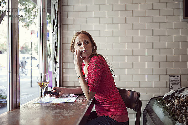 Frau schaut weg  während sie im Restaurant sitzt