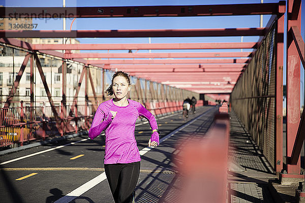 Frau läuft auf der Williamsburg Bridge Fußgängerweg