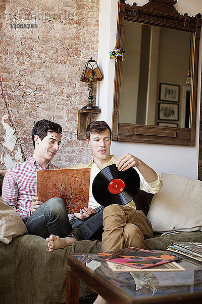 Schwule Männer  die zu Hause auf dem Sofa sitzend einen Rekord aufstellen
