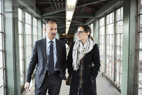 Geschäftsmann und Geschäftsfrau zu Fuß am Bahnhof