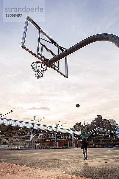 Mann übt Basketball vor Gericht gegen den Himmel