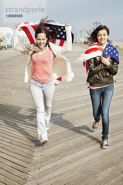 Glückliche Freunde mit amerikanischer Flagge auf dem Bodenbrett