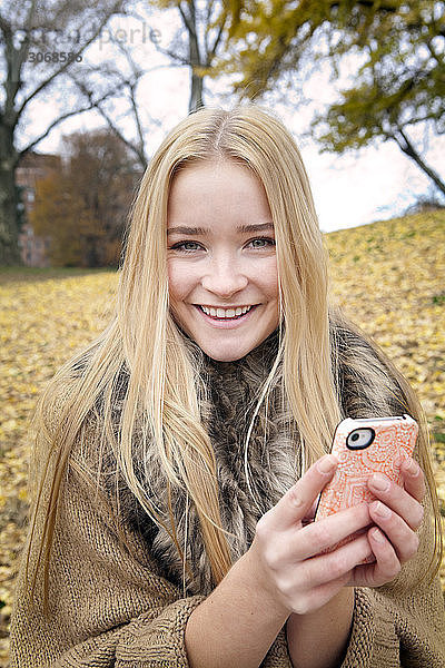 Porträt einer Frau mit Smartphone in der Hand