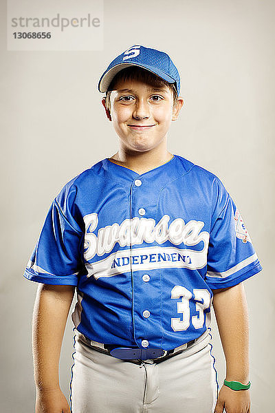 Porträt eines lächelnden Baseball-Spielers vor weissem Hintergrund