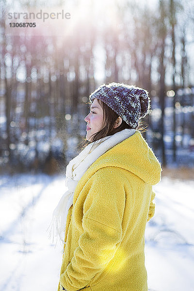 Seitenansicht einer Frau  die auf einem schneebedeckten Feld steht