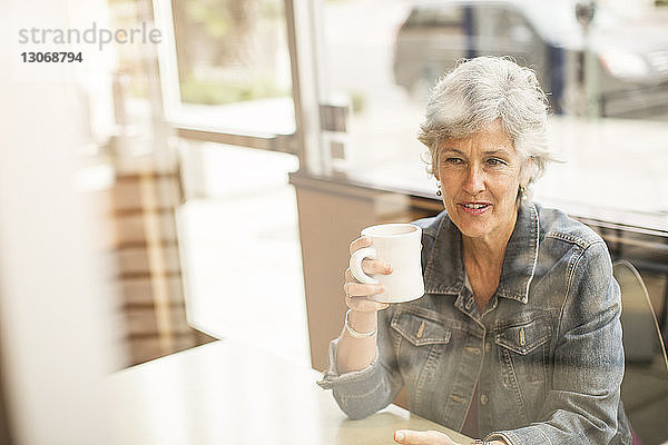 Frau schaut beim Kaffeetrinken im Café weg