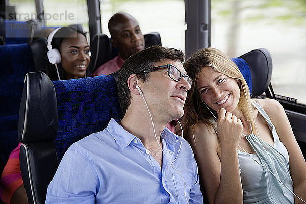 Glückliche Paare sitzen im Bus