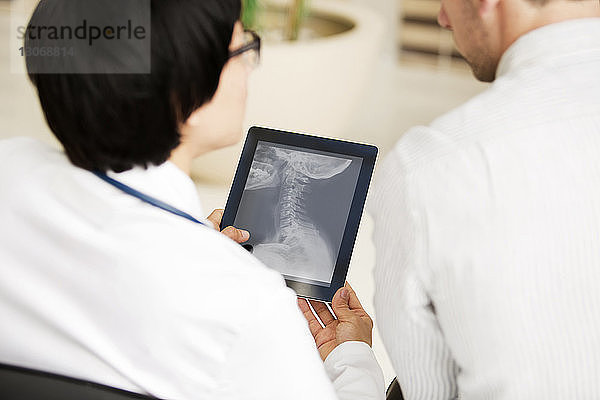 Ärzte suchen Röntgenbericht im Tablet-Computer