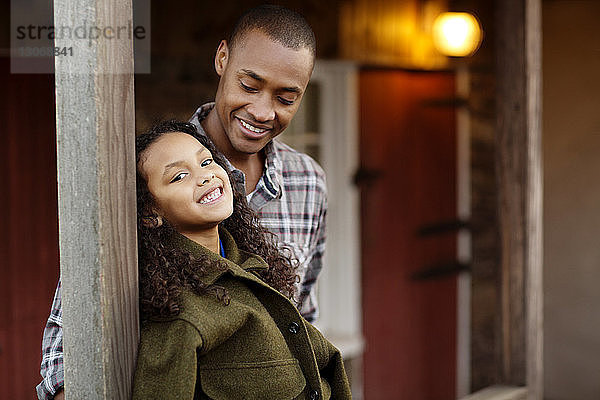 Porträt eines glücklichen Mädchens  das mit seinem Vater in der Veranda steht