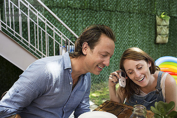 Paar hört Musik vom Mobiltelefon im Hinterhof