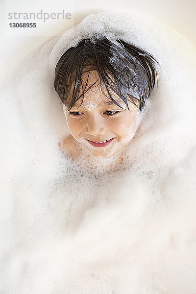 Hochwinkelansicht eines in einer Badewanne badenden Jungen