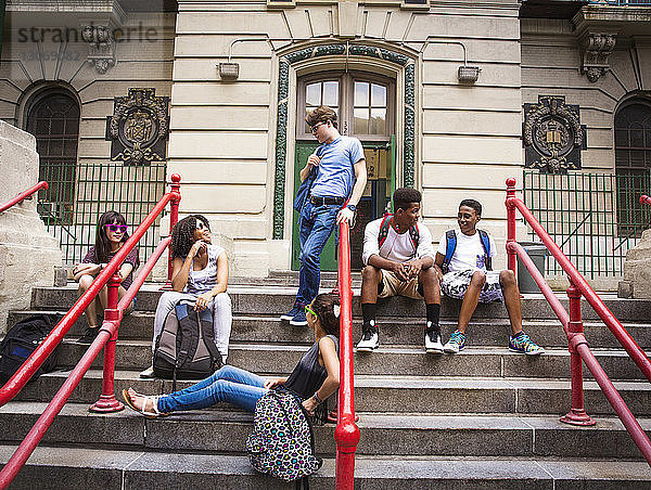 Schüler ruhen auf Stufen am Eingang der High School