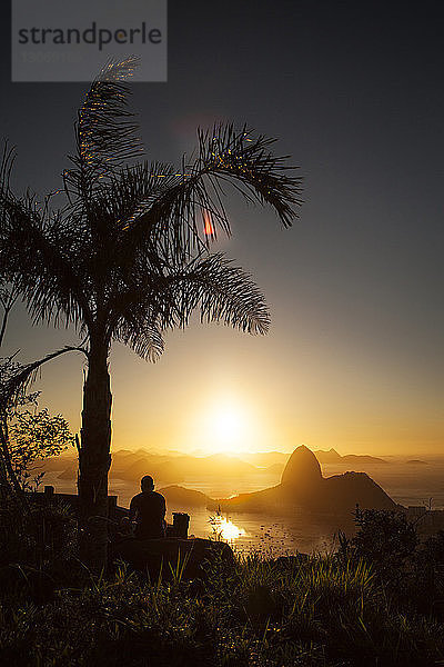 Silhouette eines Mannes gegen den Zuckerhut bei Sonnenuntergang