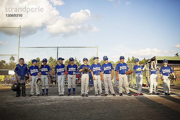 Baseball-Team steht auf dem Spielfeld gegen den Himmel