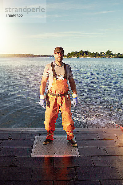 Porträt eines selbstbewussten Fischers am Pier stehend