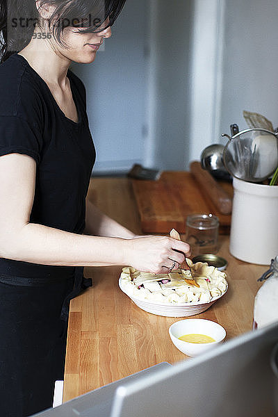 Seitenansicht einer Frau  die Ei auf Kuchen bürstet