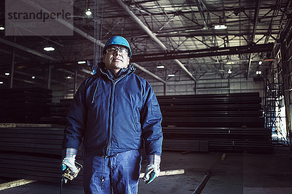 Porträt eines Arbeiters mit Fernbedienung in der Fabrik stehend