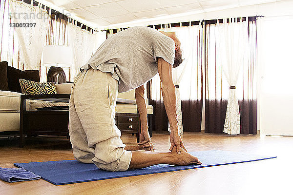 Zu Hause Yoga praktizierender Mann