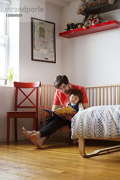 Vater und Tochter lesen zu Hause ein Buch