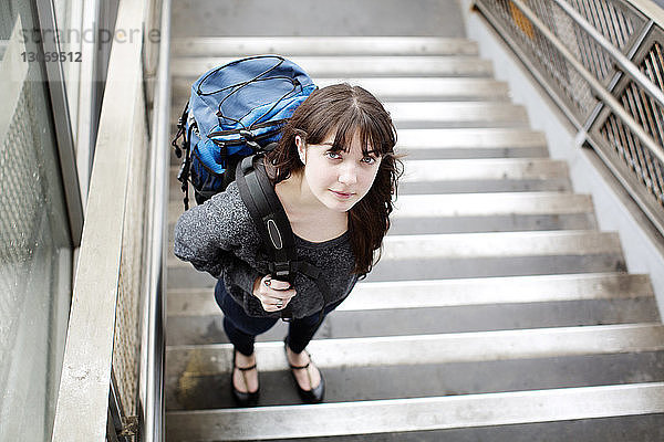 Porträt einer Frau  die auf einer Treppe am Bahnhof steht