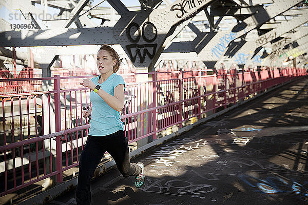 Weibliche Athletin läuft auf der Williamsburg Bridge Fußgängerzone