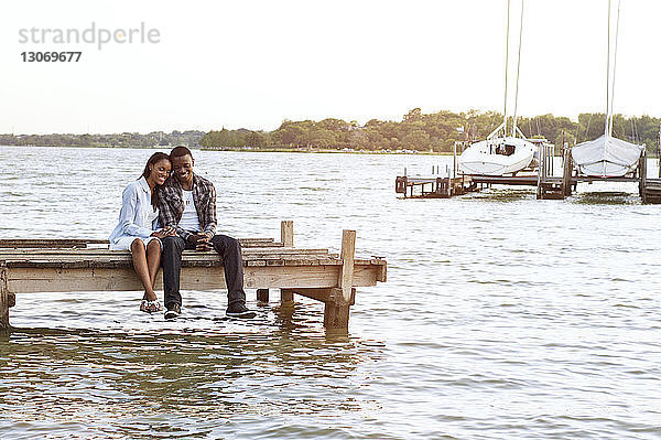 Glückliches Paar am Pier sitzend