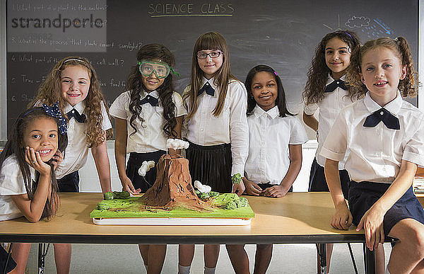 Porträt von Schulmädchen mit Wissenschaftsprojekt am Schreibtisch im Klassenzimmer