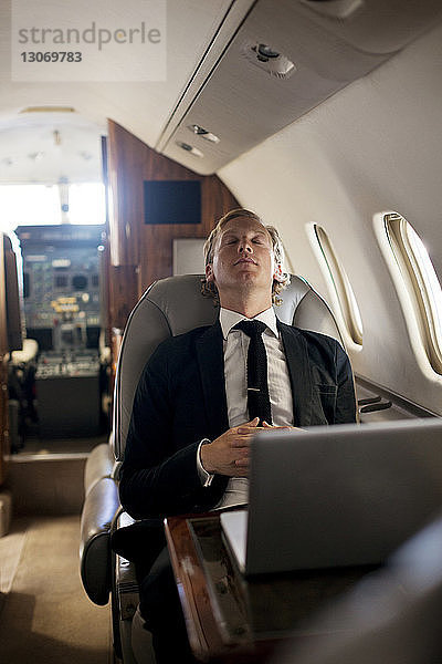 Geschäftsmann entspannt sich im Flugzeug