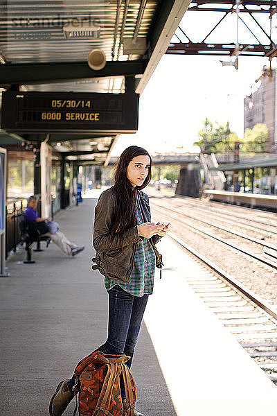 Frau schaut weg  während sie auf dem Bahnsteig steht