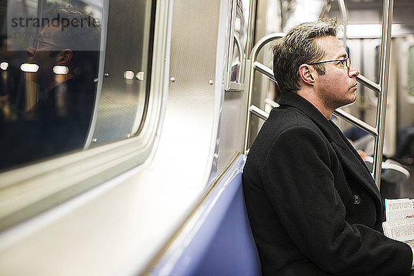 Mann schaut weg  während er in der U-Bahn fährt