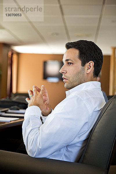 Geschäftsmann schaut weg  während er während einer Sitzung im Büro sitzt