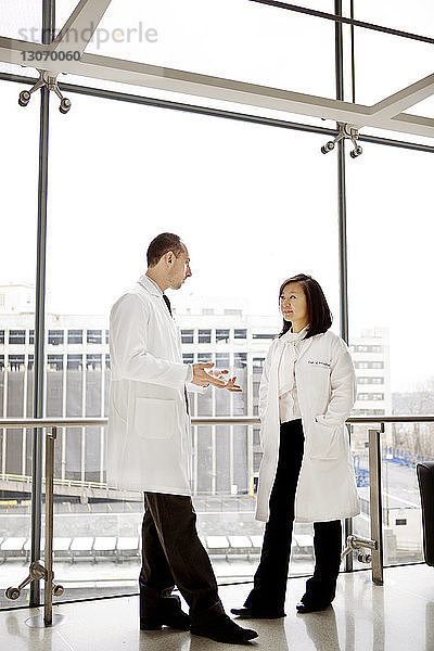 Ärzte sprechen  während sie im Krankenhaus am Fenster stehen
