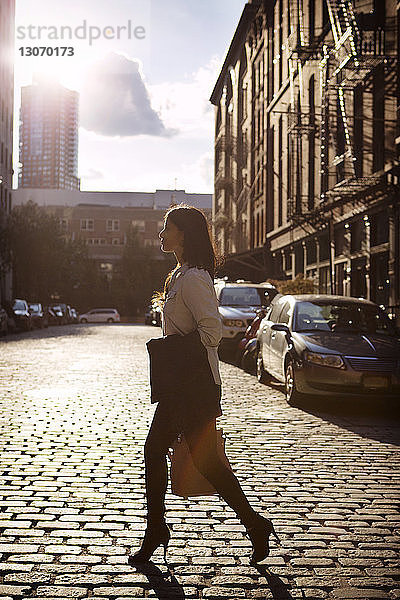 Seitenansicht einer Frau  die auf einer Straße in der Stadt geht