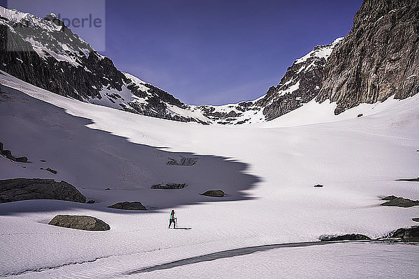 Frau wandert am schneebedeckten Berg