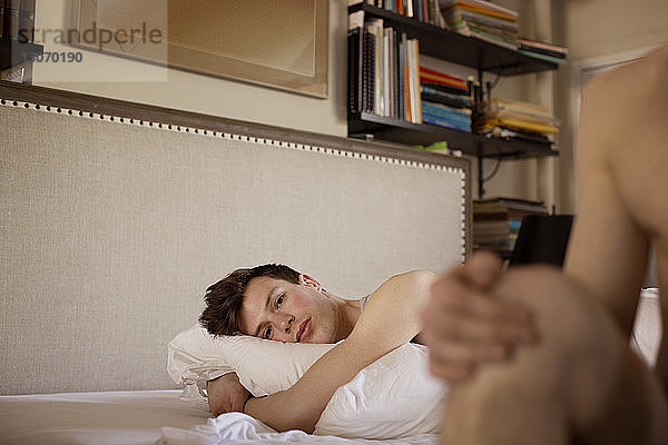 Porträt eines schwulen Mannes  der sich zu Hause auf dem Bett ausruht