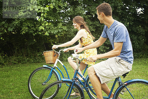Glückliches Paar beim Fahrradfahren im Park