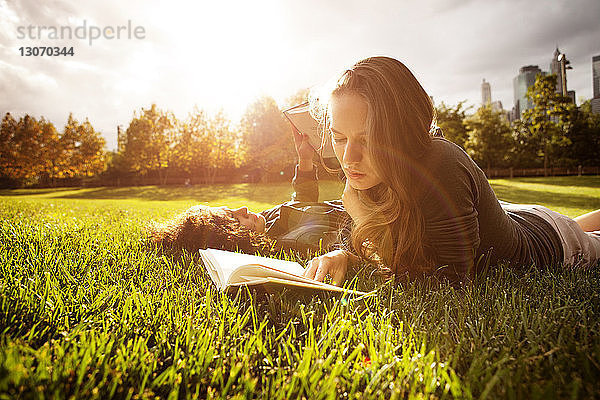 Freunde lesen Bücher  während sie auf dem Rasen liegen