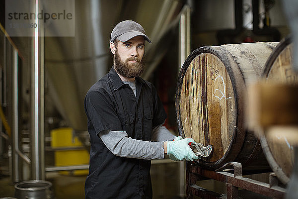 Porträt eines Mannes  der Fässer in einer Brauerei repariert