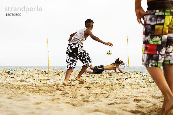 Jungen spielen am Strand