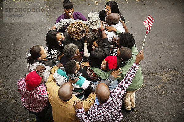 Familie umarmt Soldat  während er auf der Straße steht