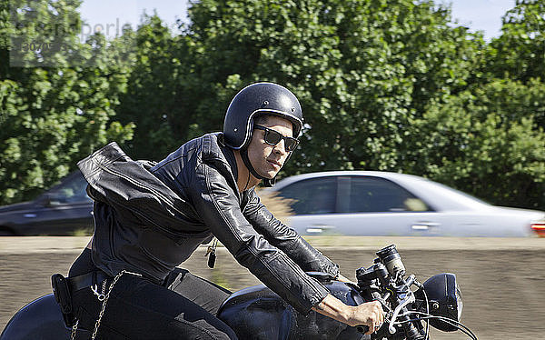 Zuversichtlicher Mann fährt Motorrad auf der Straße