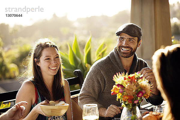 Glücklicher Mann schaut weg  während er mit Frau am Esstisch sitzt