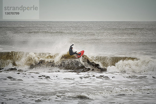 Mann surft im Meer